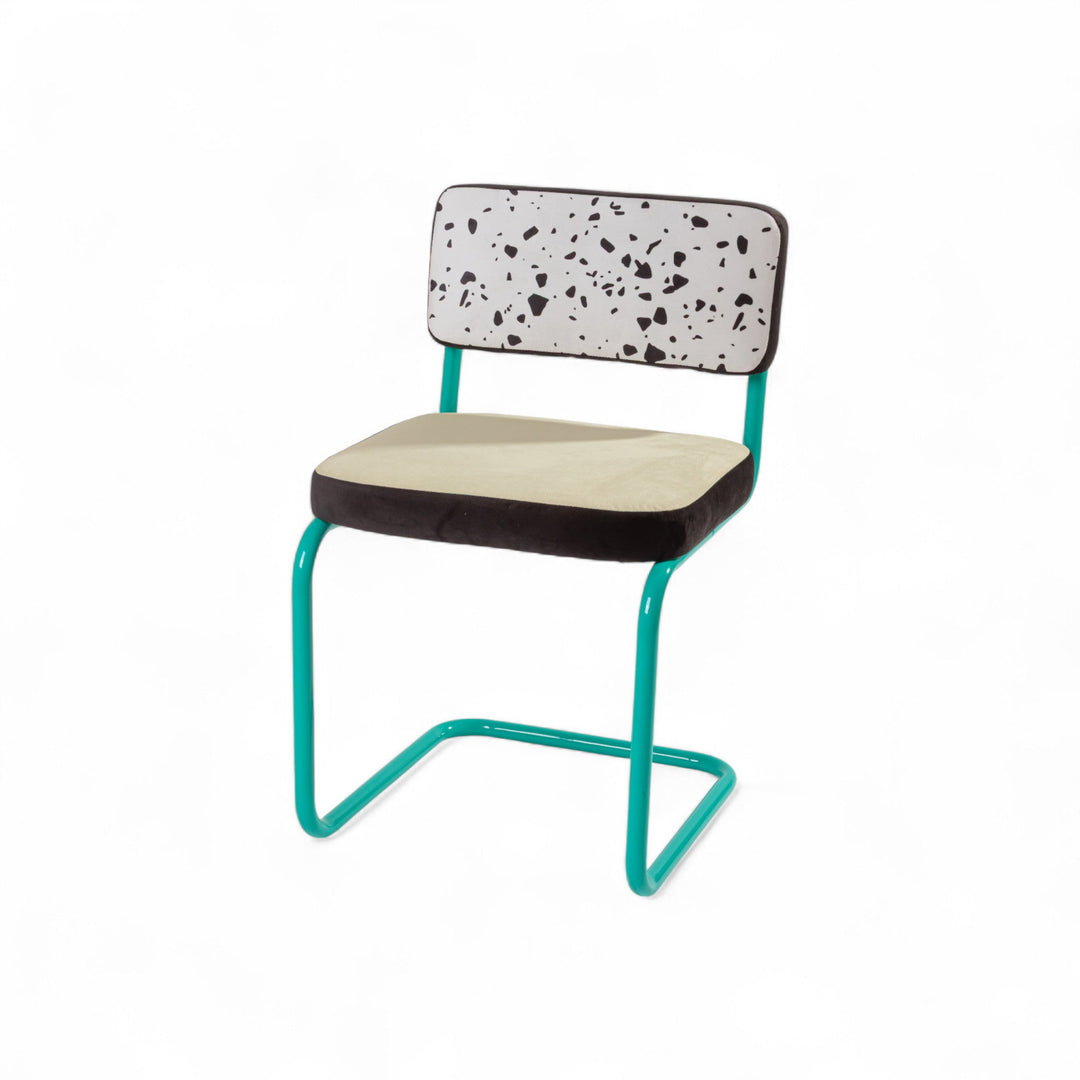Terrazzo-patterned accent chair with teal metal frame and minimalist design