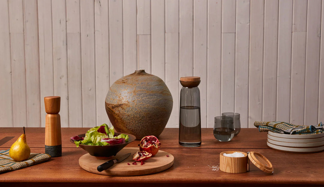 Pepper grinder by Holcomb Design in wood and stone on a refined kitchen table setting.