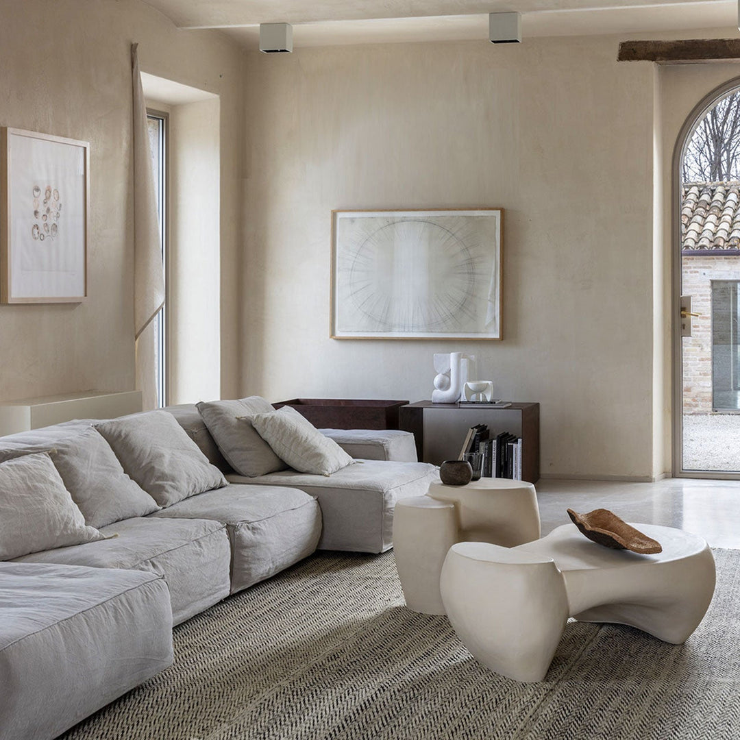 Sculptural stone coffee tables in a designer living room with textured neutral sofa