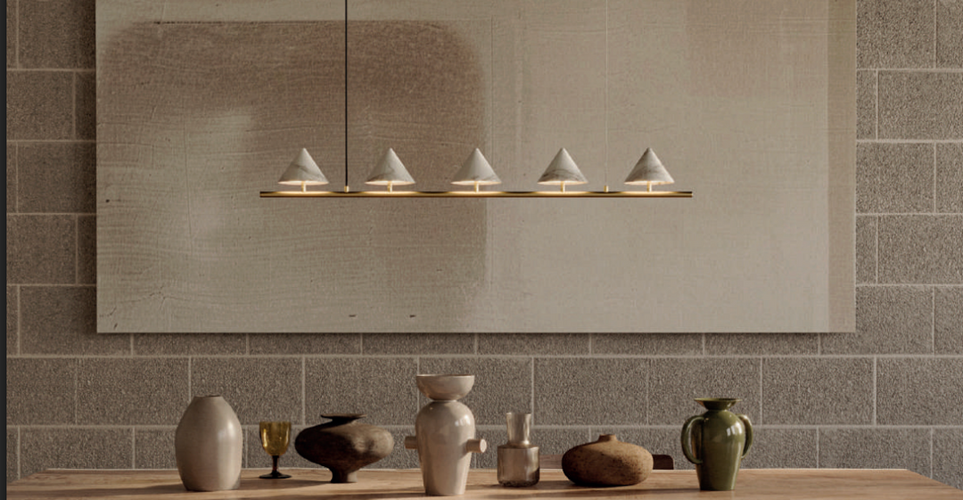 Sculpted oak dining table with ribbed pedestal base, paired with ceramic vases and a modern ring pendant light.