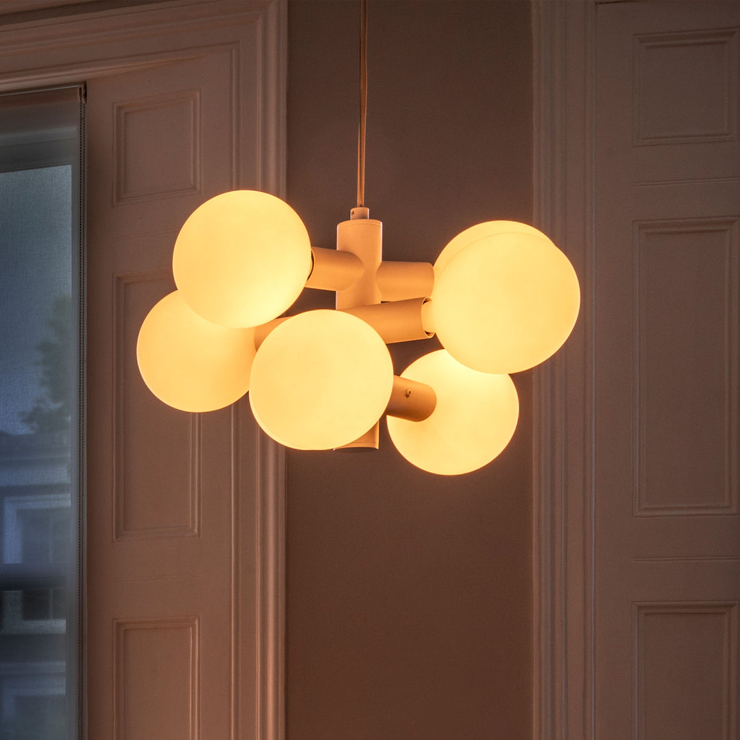 Sculptural glass globe chandelier with matte finish, modern lighting in elegant interior.