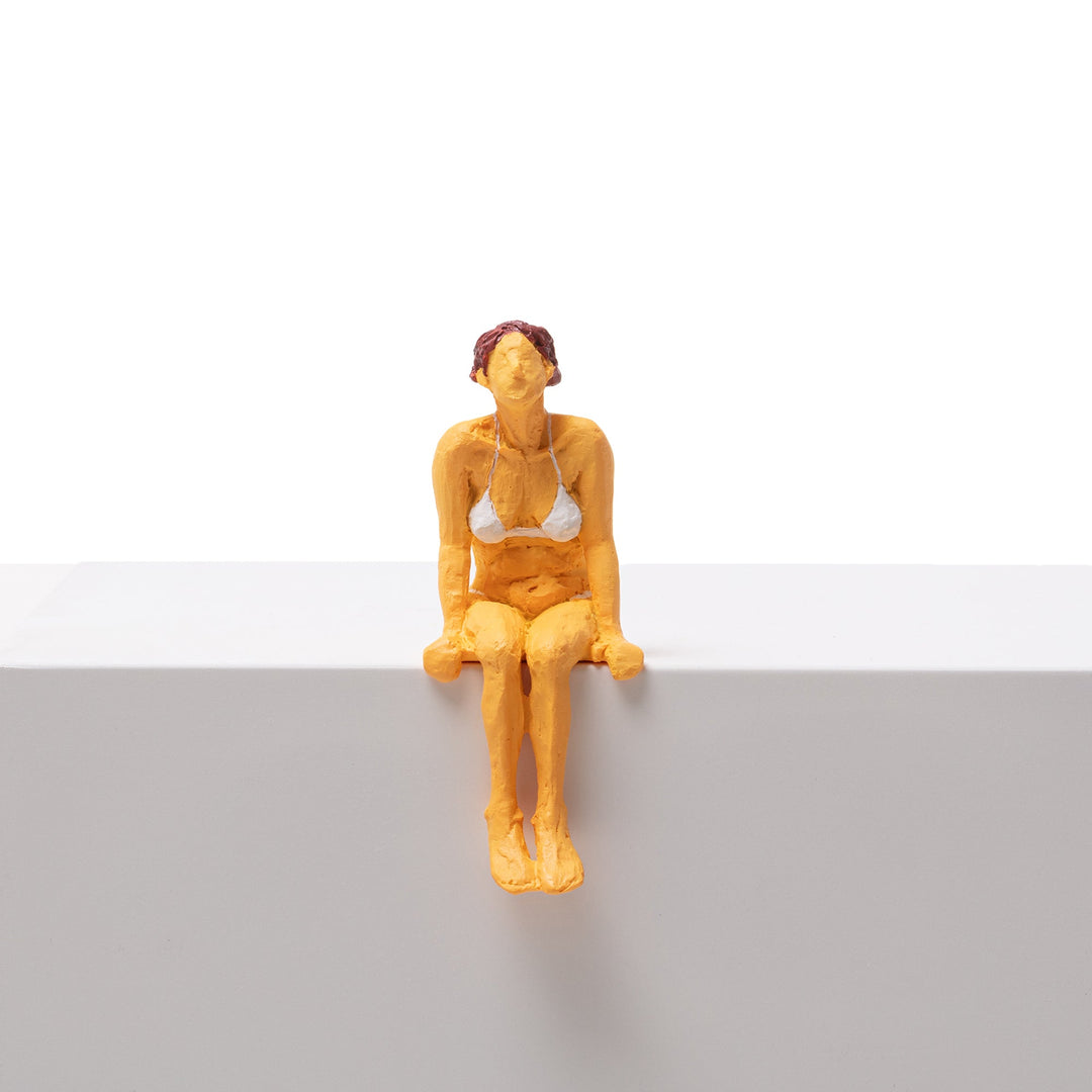 Seletti Love Is a Verb Tanya Figurine, ochre resin woman in a white bikini perched on a ledge
