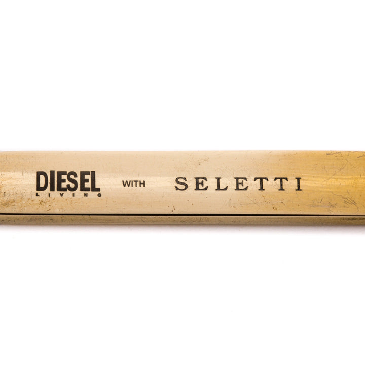 Seletti Cosmic Diner Lunar Stirrer, close-up of the Diesel with Seletti stamp on the brass