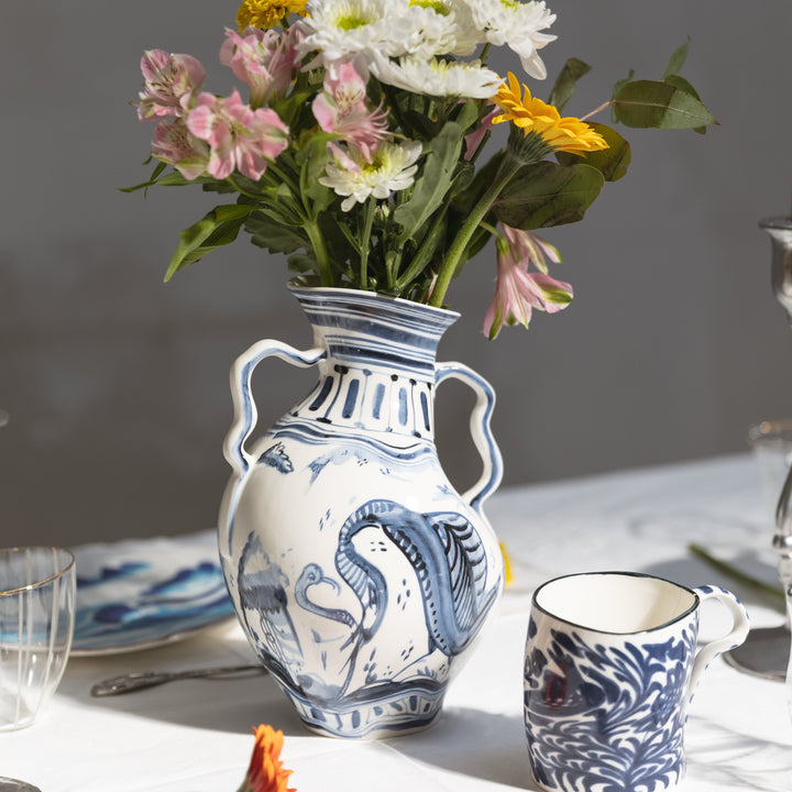 Seletti Classics on Acid Ibex Blue and White Vase, the vase filled with flowers on a set table beside a blue patterned mug