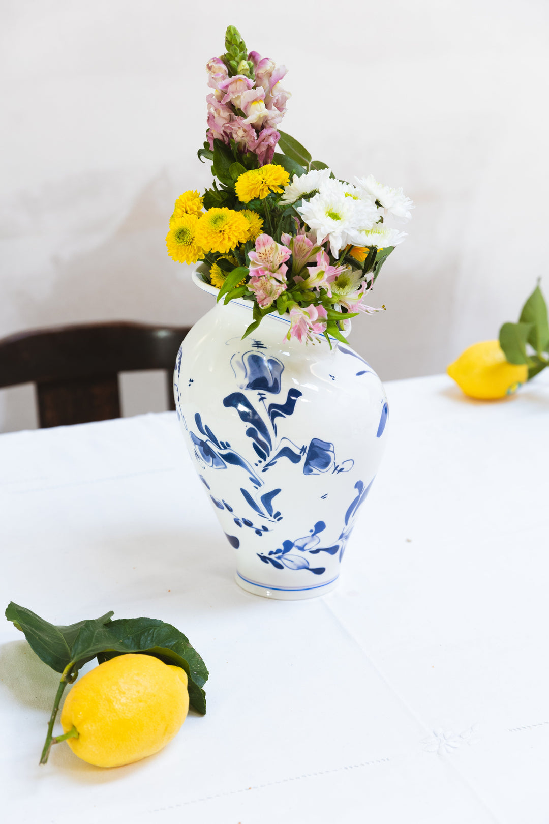 Seletti Classics on Acid Floral Delft Vase, the vase holding a bouquet on a white table with lemons