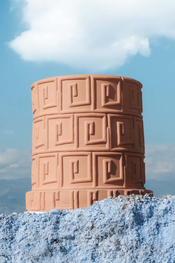 Seletti Magna Graecia Terracotta Vase Greca, the pot set on blue rock against a cloudy sky