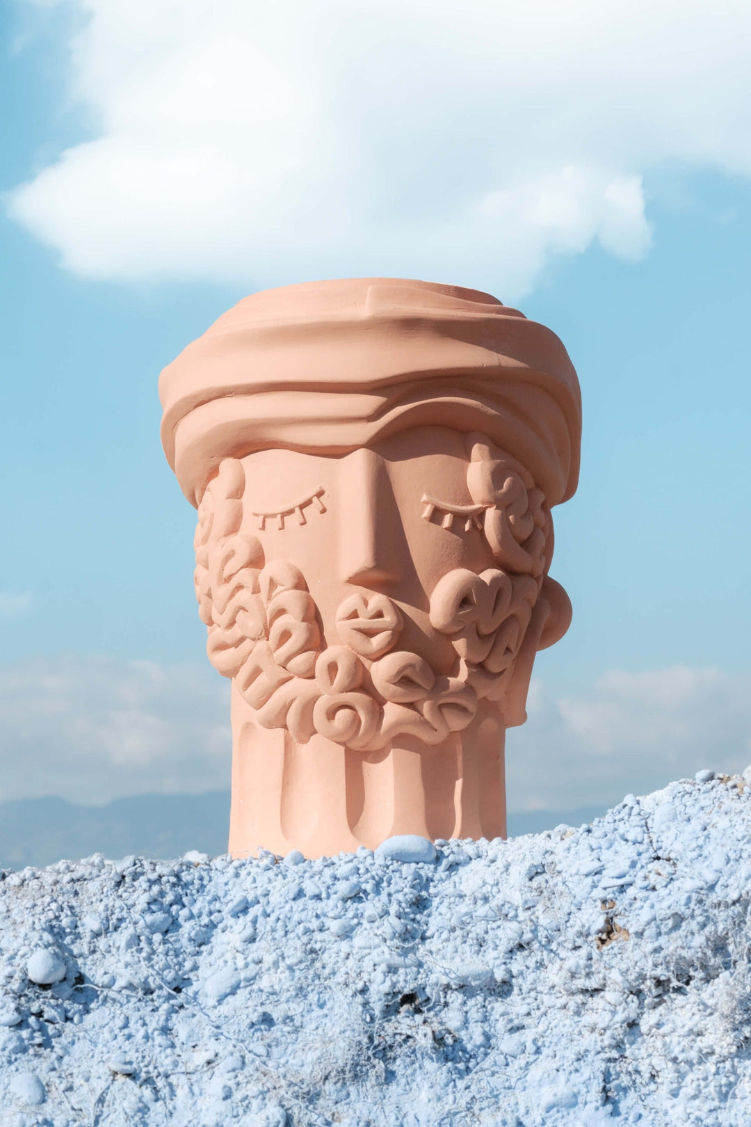 Seletti Magna Graecia Terracotta Head Vase Man, the vase posed on blue rock against the sky