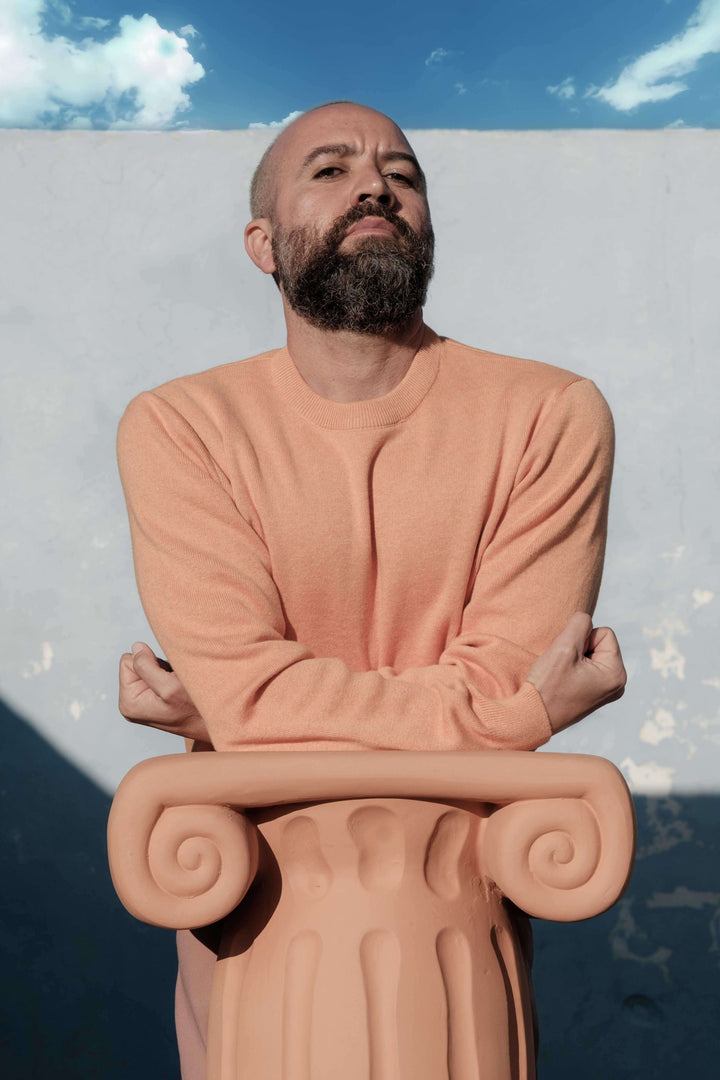 Seletti Magna Graecia Terracotta Capitello Stool, a man leaning on the capital outdoors