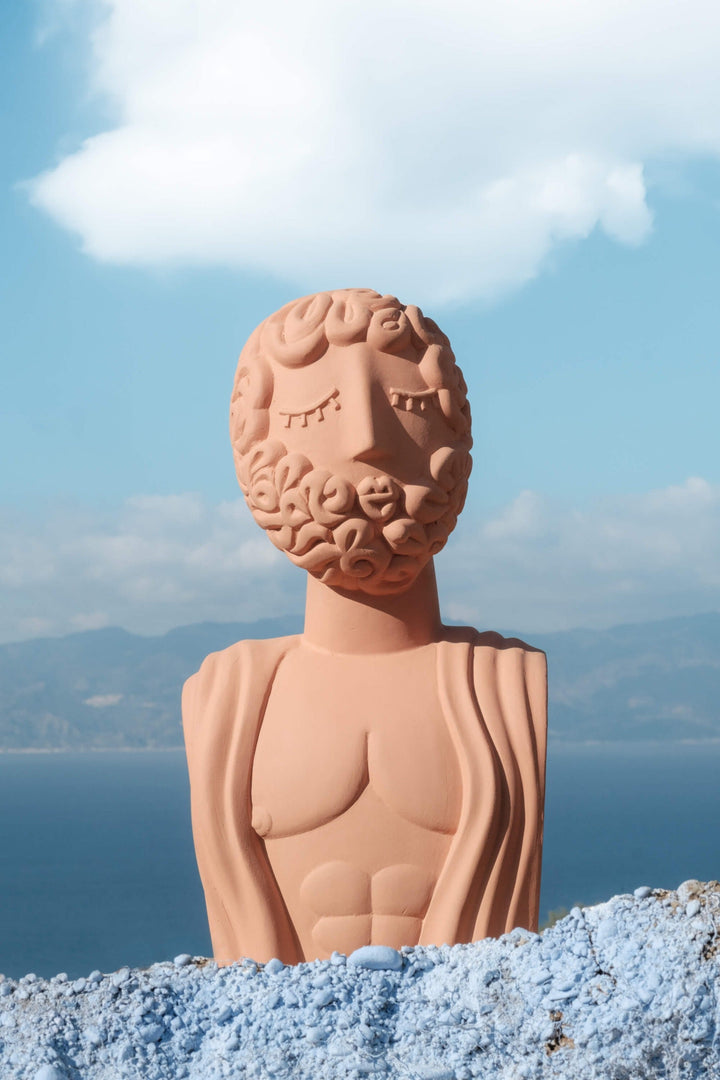 Seletti Magna Graecia Terracotta Bust Man, the bust set on blue rock with the sea behind
