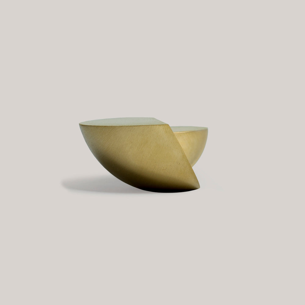 Sculptural brass decorative bowl with geometric modern design on neutral background