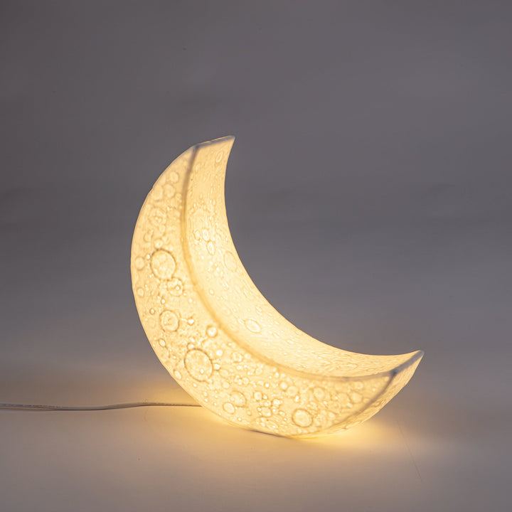 Seletti My Tiny Moon Lamp, front view of the glowing moon lamp casting light below it