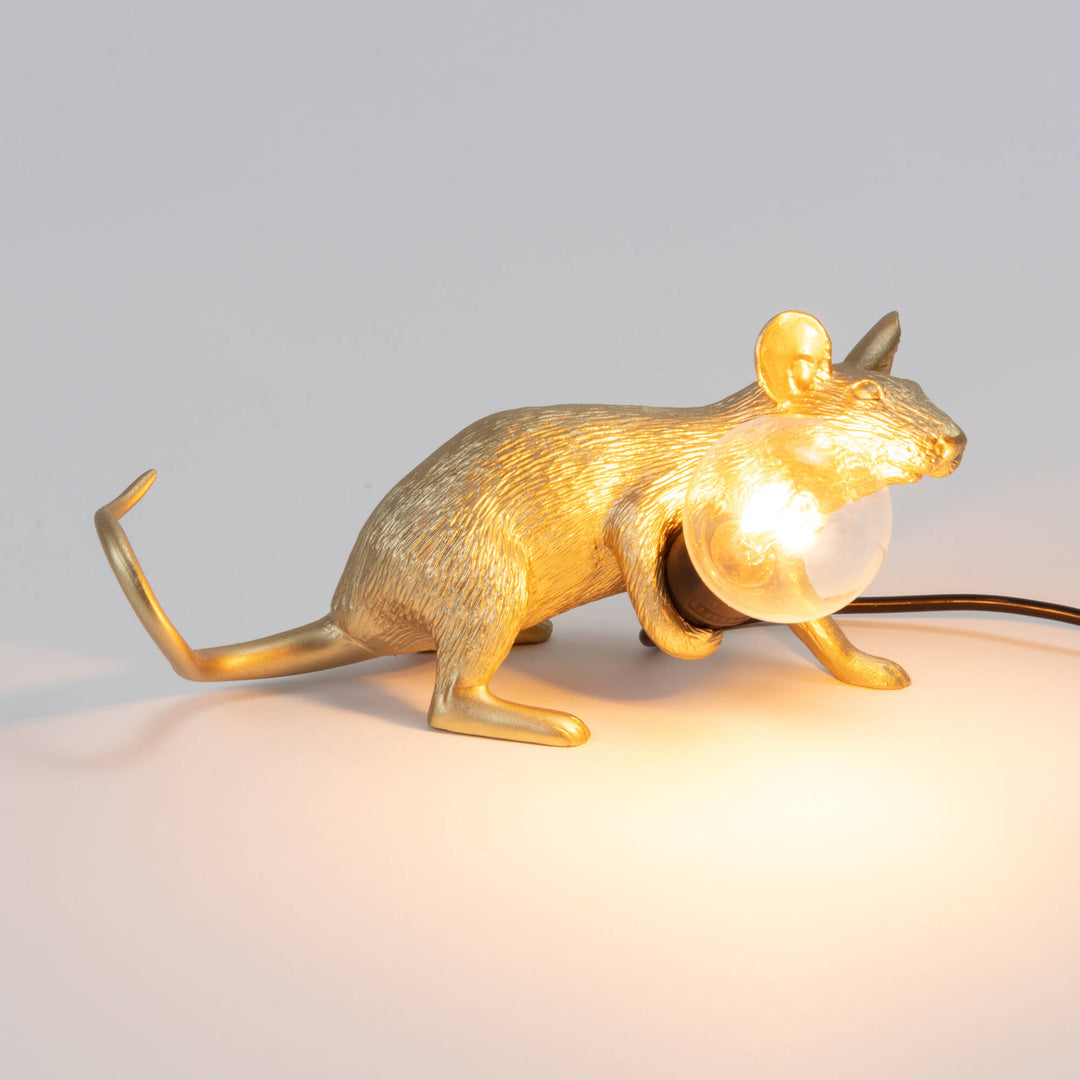 Seletti Mouse Lamp Lop Lying Down Gold, side view of the lit gold mouse lying low on a gray surface