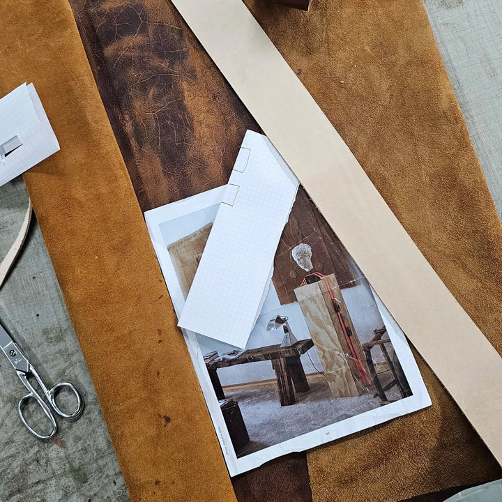 Impermanence Stainless Steel &amp; Leather Wall Light — studio process shot, leather straps being cut