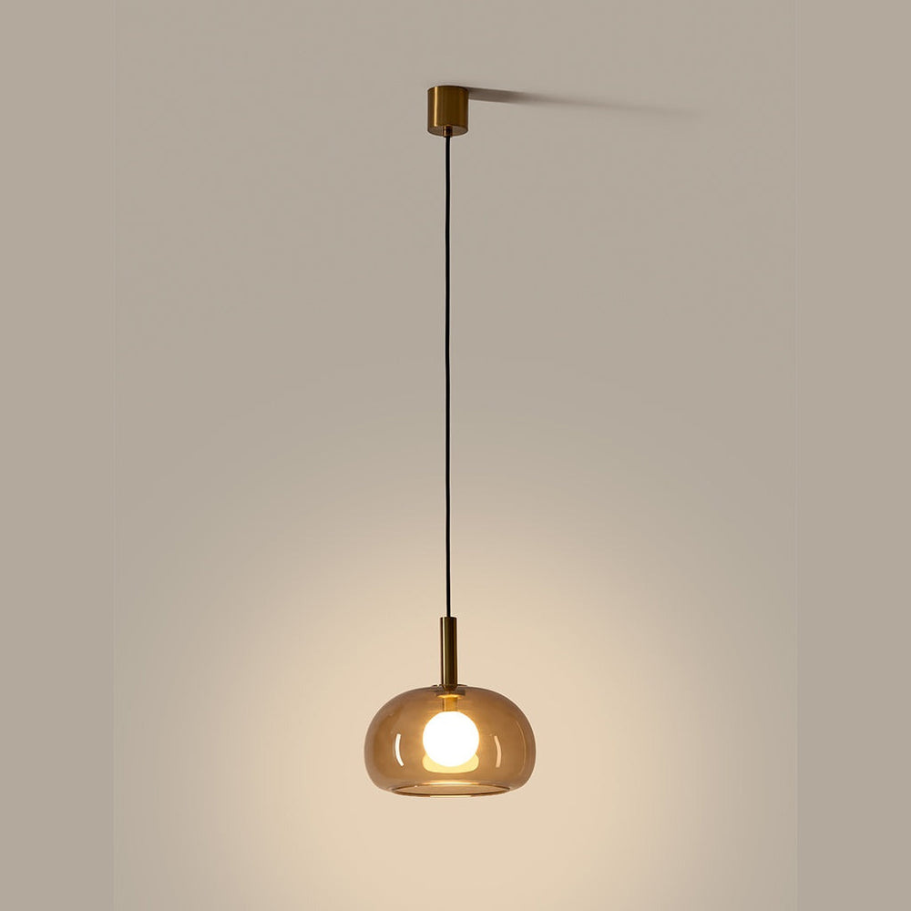 Cloud Single Pendant Lamp lit, aged gold fittings and smoked glass dome with glowing opal bulb