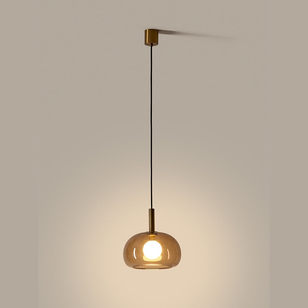 Cloud Single Pendant Lamp lit, aged gold fittings and smoked glass dome with glowing opal bulb
