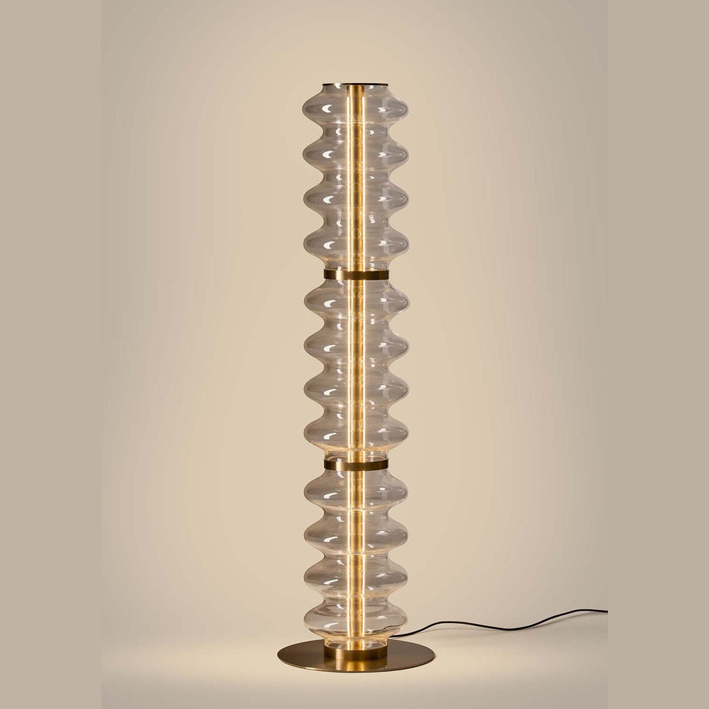 Vitree Floor Lamp lit, warm LED glow running through the clear wavy glass column