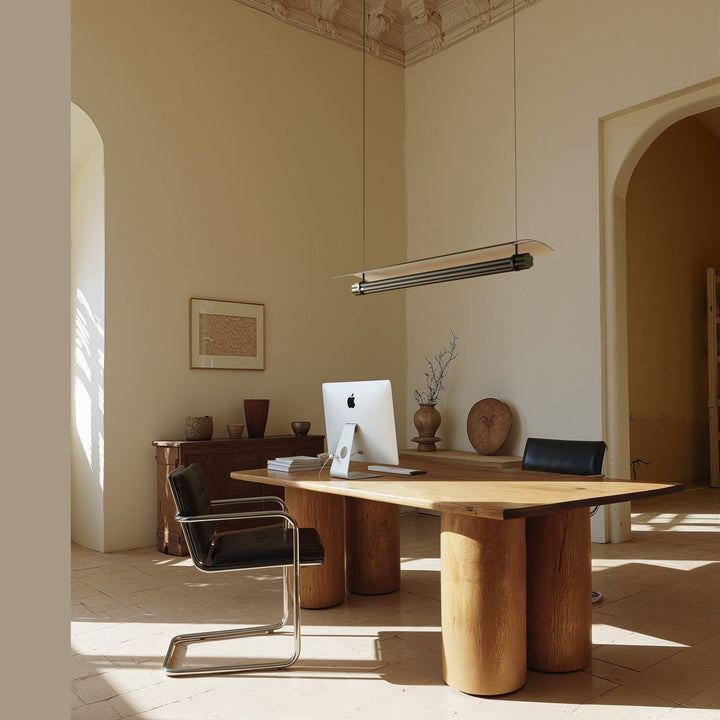 Tasta Pendant Lamp lit above a wooden desk in a high-ceilinged office with arched doorways