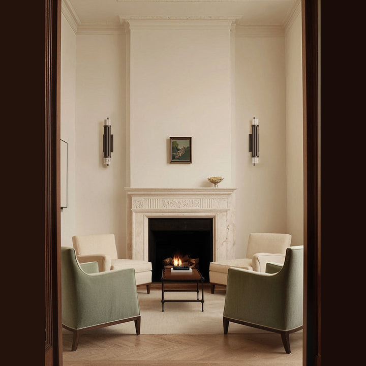 Pair of Tasta Wall Lamps flanking a marble fireplace in a cream sitting room with green armchairs