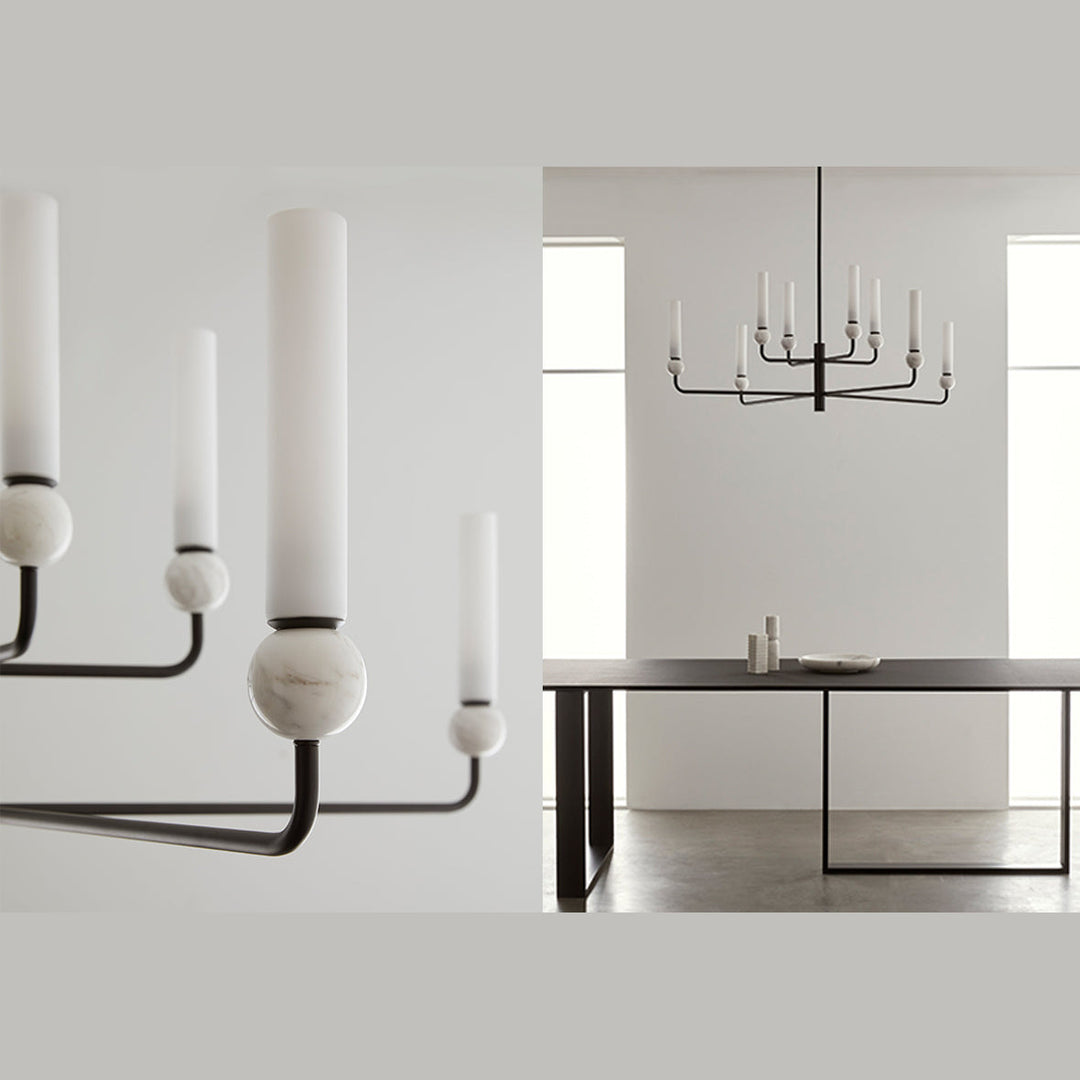 Black chandelier with white marble spheres and opal glass tubes above a long dining table