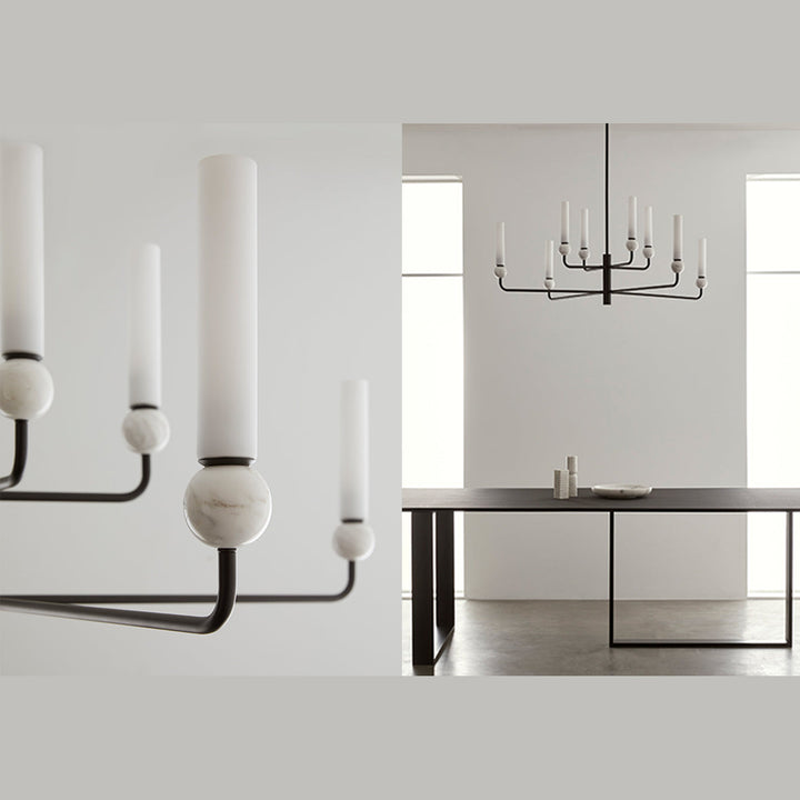 Black chandelier with white marble spheres and opal glass tubes above a long dining table