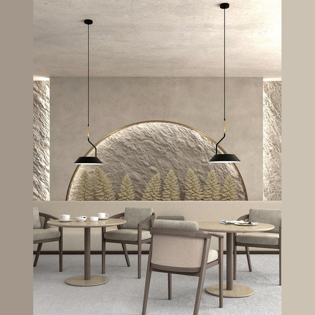 Two Aider Pendant Lamps over round tables in a restaurant with a sculpted arched wall