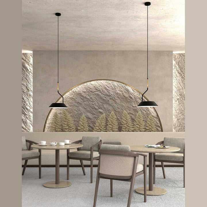 Two Aider Pendant Lamps over round tables in a restaurant with a sculpted arched wall