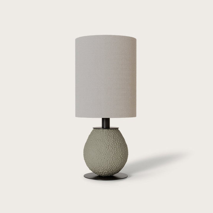 Anada Table Lamp with textured sage-green ceramic base and tall grey drum shade, off-centre, by Aromas del Campo
