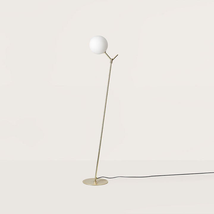 Atom Floor Lamp with an opal glass globe on a slim angled matt brass stem and round base, by Aromas del Campo