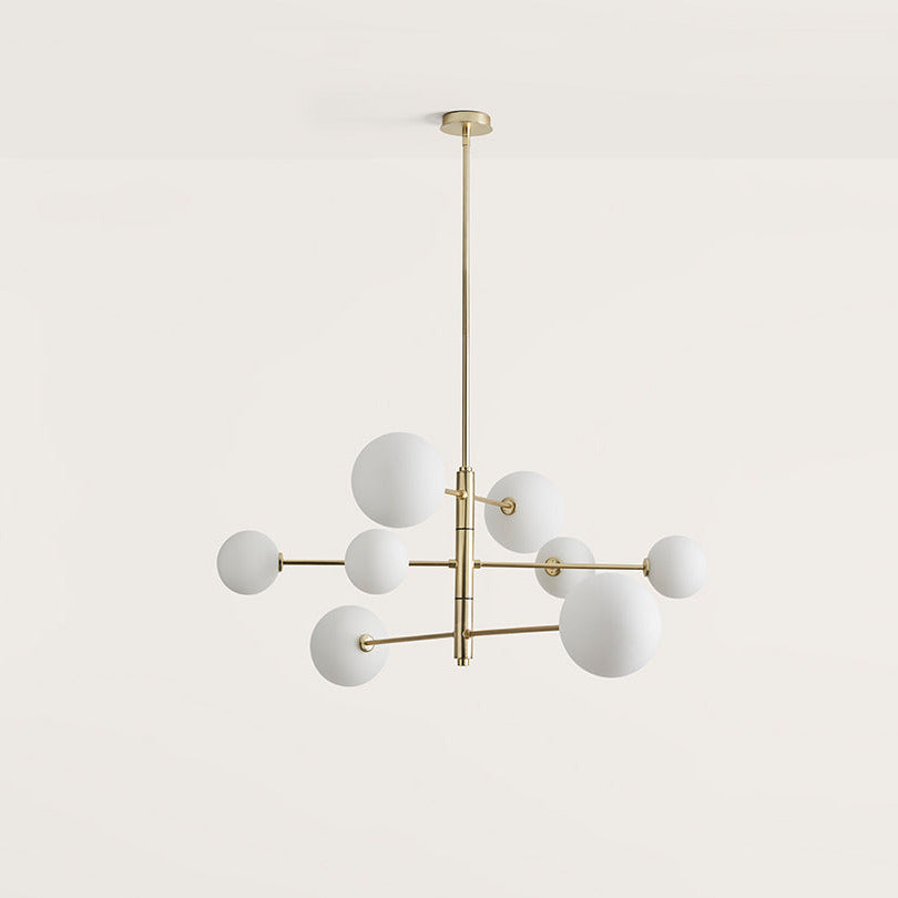 Atom Chandelier with eight opal glass globes on staggered matt brass arms, front view, by Aromas del Campo