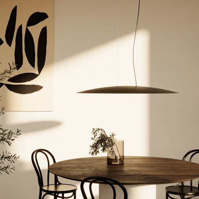 Bigcoss Pendant Lamp hanging over a round wooden dining table with bentwood chairs in warm light