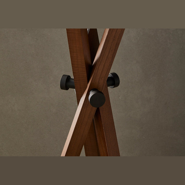 Cot Floor Lamp close-up of crossed walnut legs and black metal joint knobs