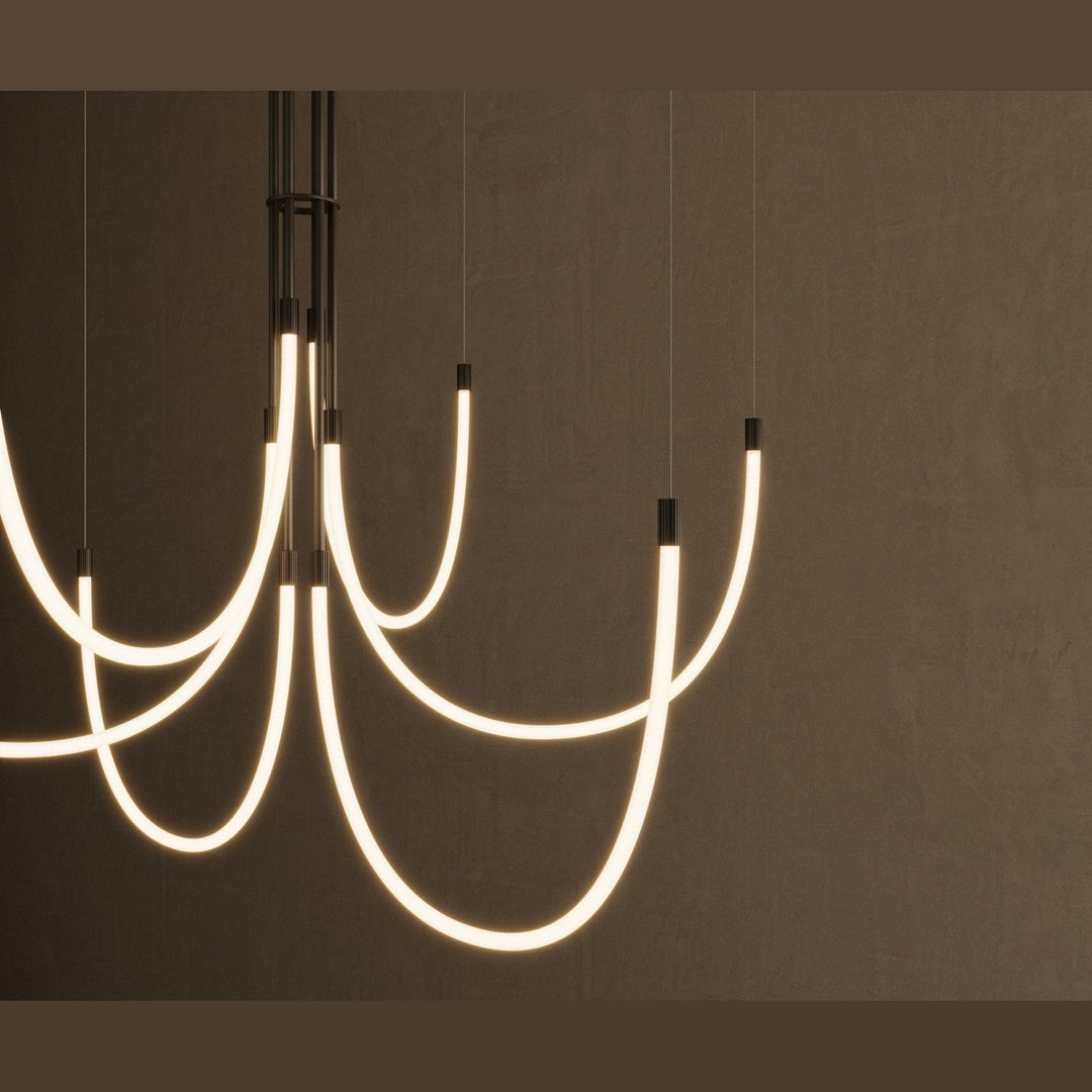 Cram Chandelier Chandelier close-up of glowing curved tubes and black fittings against a dark wall