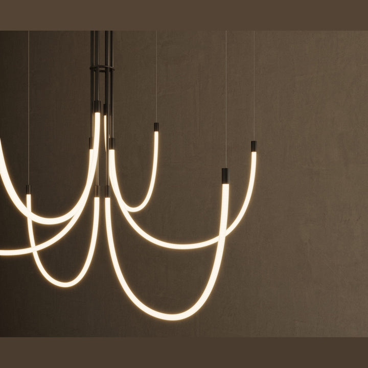 Cram Chandelier Chandelier close-up of glowing curved tubes and black fittings against a dark wall