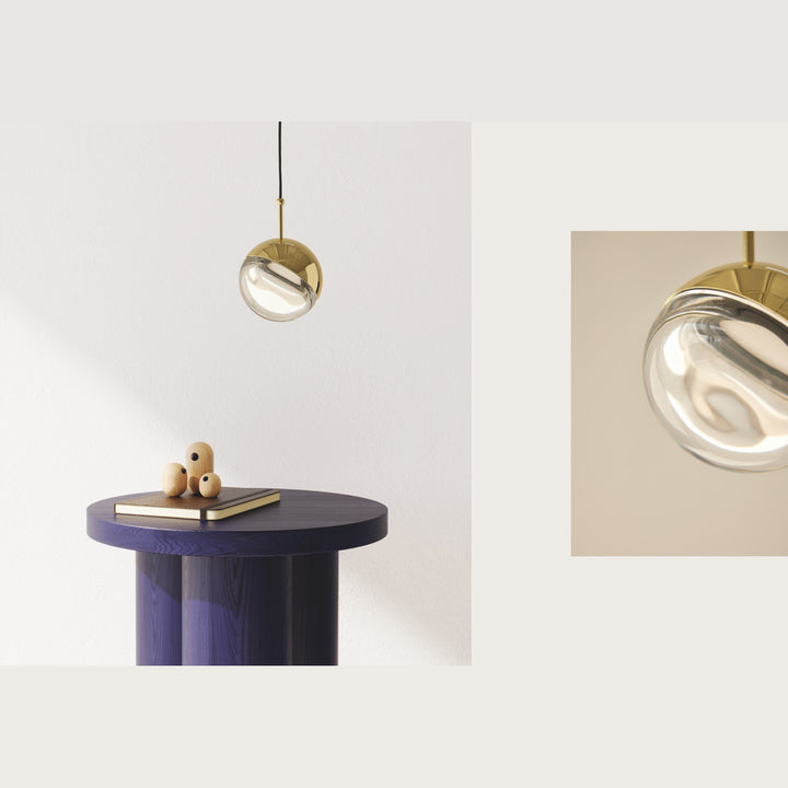 Dora Pendant Lamp hanging beside a navy side table, with a close-up of its glass globe