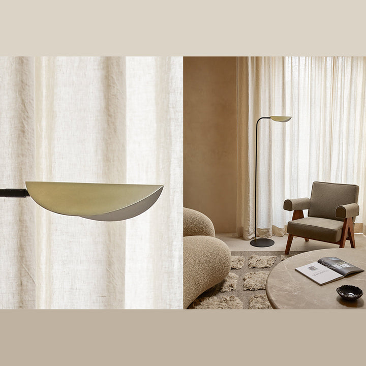 Leaf-shaped brass shade close-up beside the floor lamp in a lounge with an armchair and round coffee table