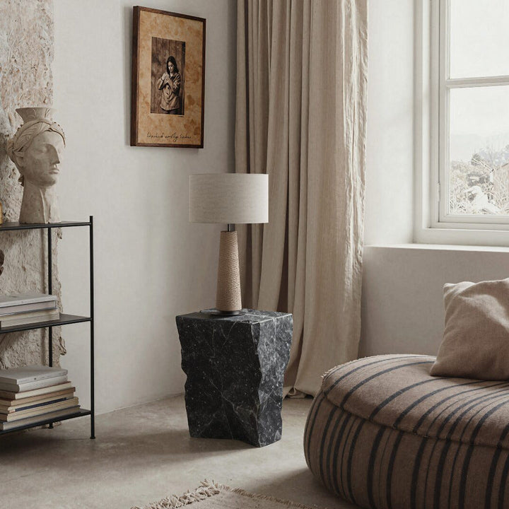Fill Table Lamp with a beige base and linen shade on a black stone plinth by a window with linen curtains