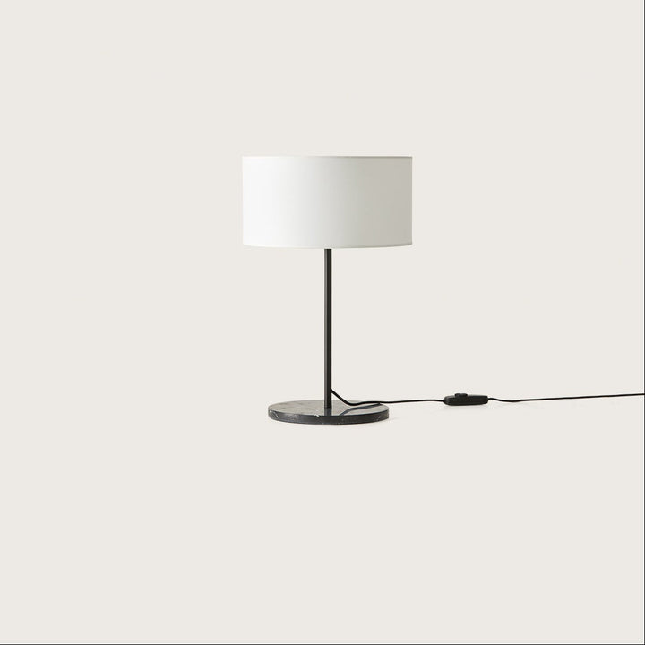 Hedra Table Lamp with a black stem, black marble base and white drum shade, unlit, by Aromas del Campo