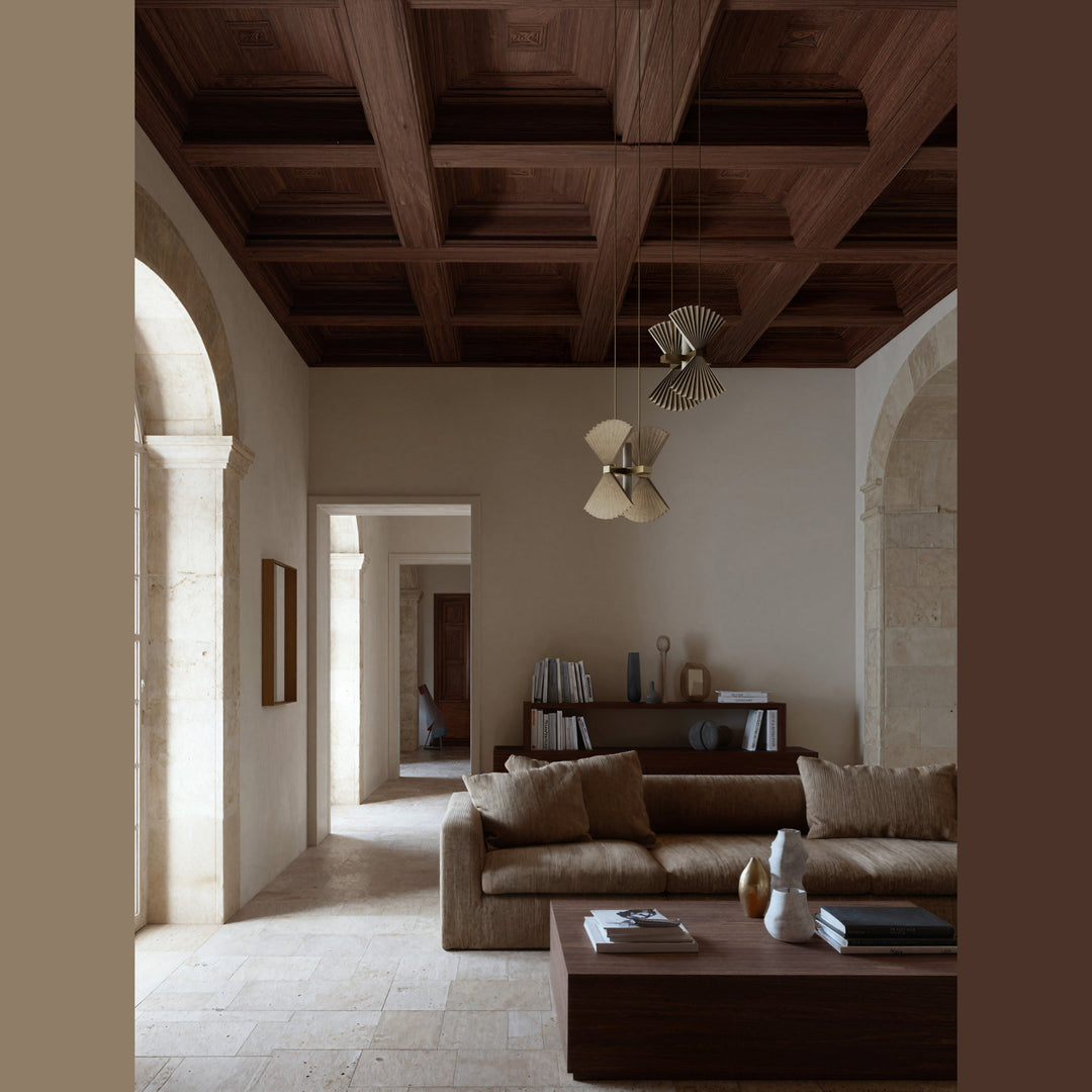 Two Hita pendants hung from a coffered wooden ceiling above a sofa in a stone-floored living room