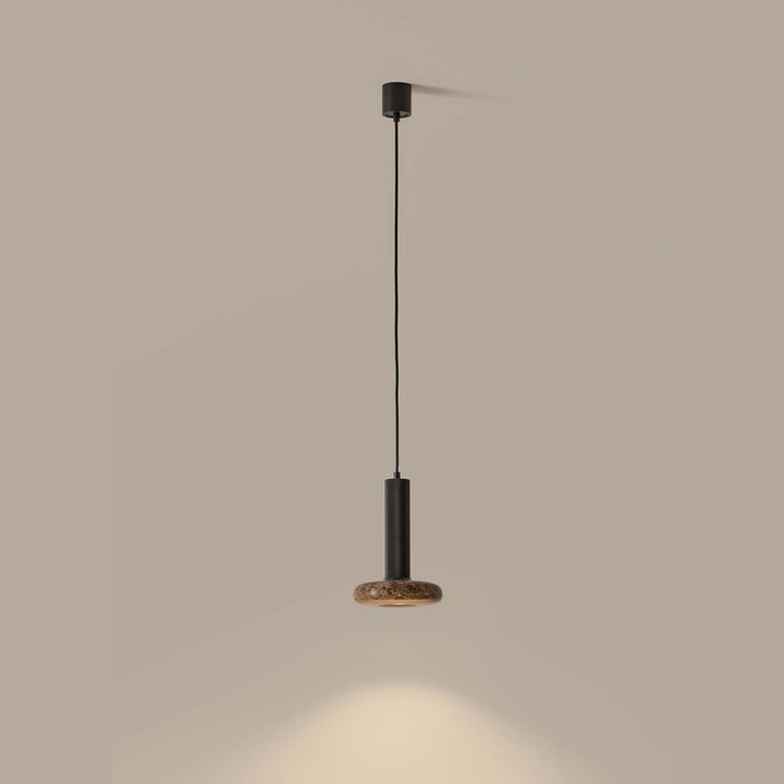Hulo Pendant Lamp with brown marble disc, lit and casting a pool of light on the wall