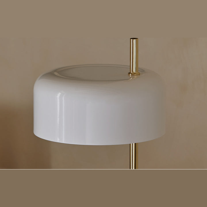 Close-up of the white ceramic shade glowing on its brass stem