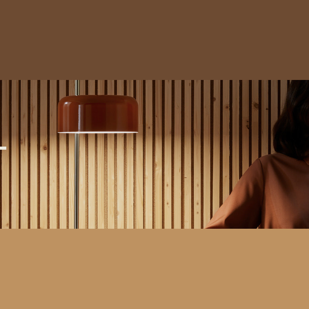 Detail of the red shade above slatted wood panels with warm light