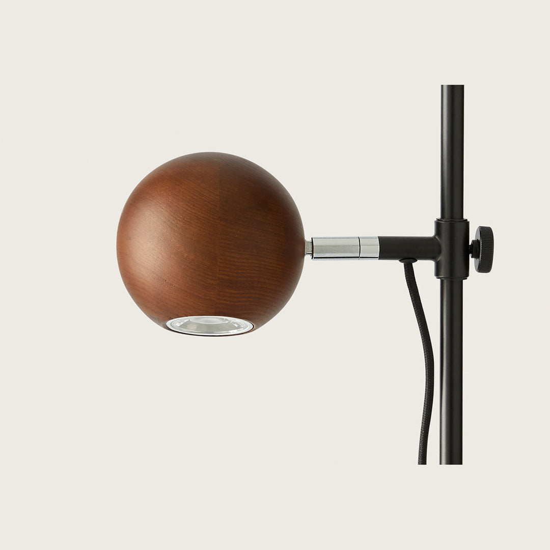 Lita Table Lamp close-up of the walnut wood sphere, LED opening and black clamp knob