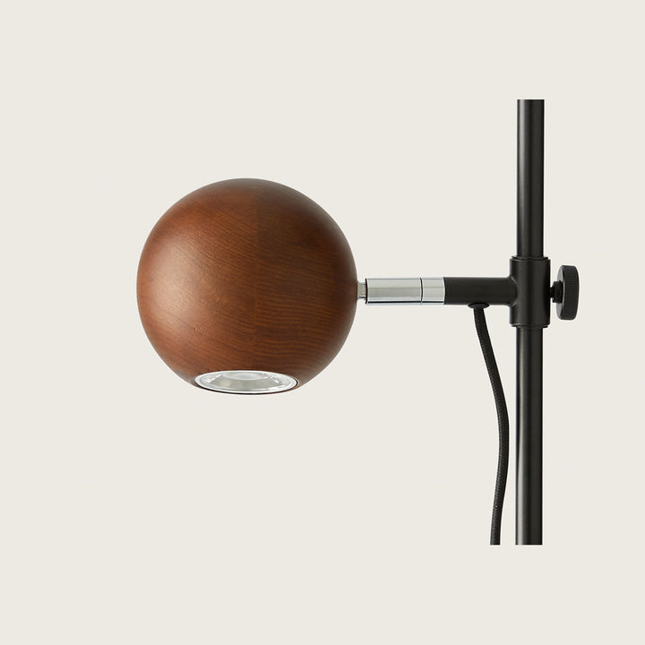 Lita Table Lamp close-up of the walnut wood sphere, LED opening and black clamp knob