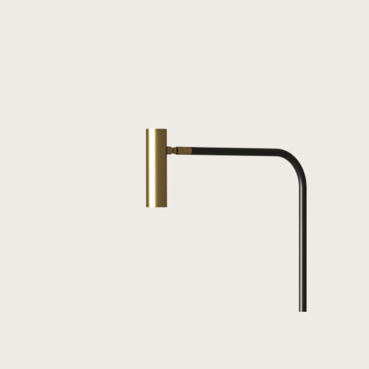 Close-up of the Maho Floor Lamp brass cylinder head on its black curved arm