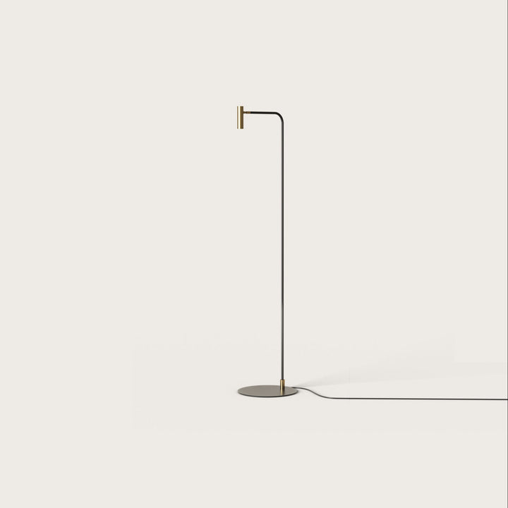 Maho Floor Lamp, slim black stem curving to a small brass cylinder spotlight head, by Aromas del Campo