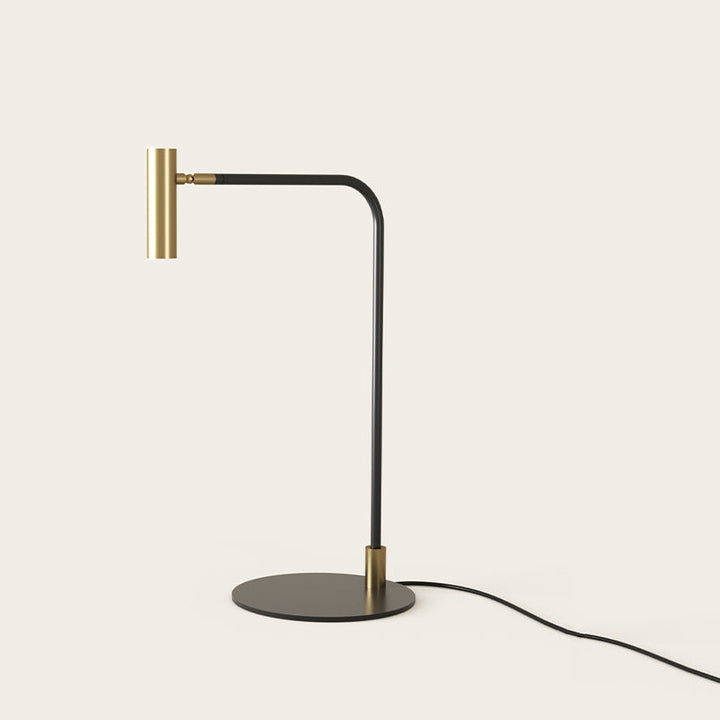 Maho Table Lamp with black bent stem, brass cylinder head and round black base, unlit, by Aromas del Campo
