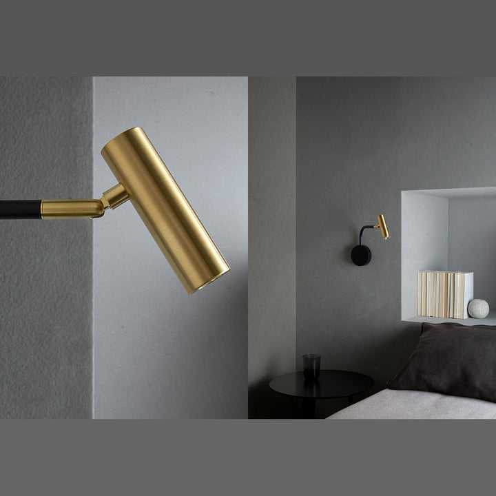 Maho Wall Lamp close-up of the brass head beside a bedroom with a niche shelf of books