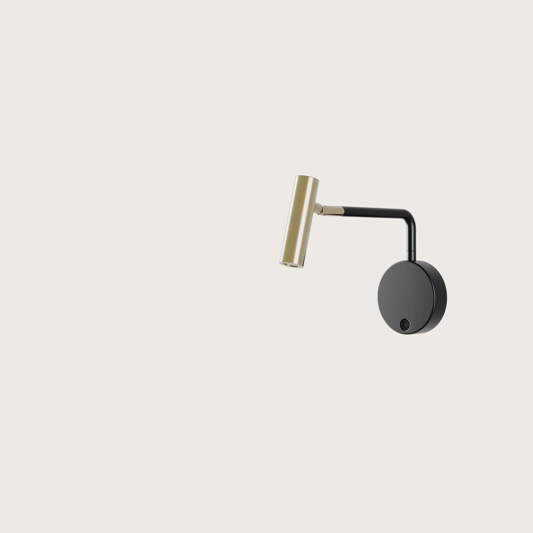 Maho Wall Lamp reading light with brass cylinder head, black arm and round black wall plate, by Aromas del Campo