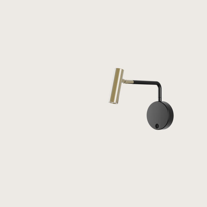 Maho Wall Lamp reading light with brass cylinder head, black arm and round black wall plate, by Aromas del Campo