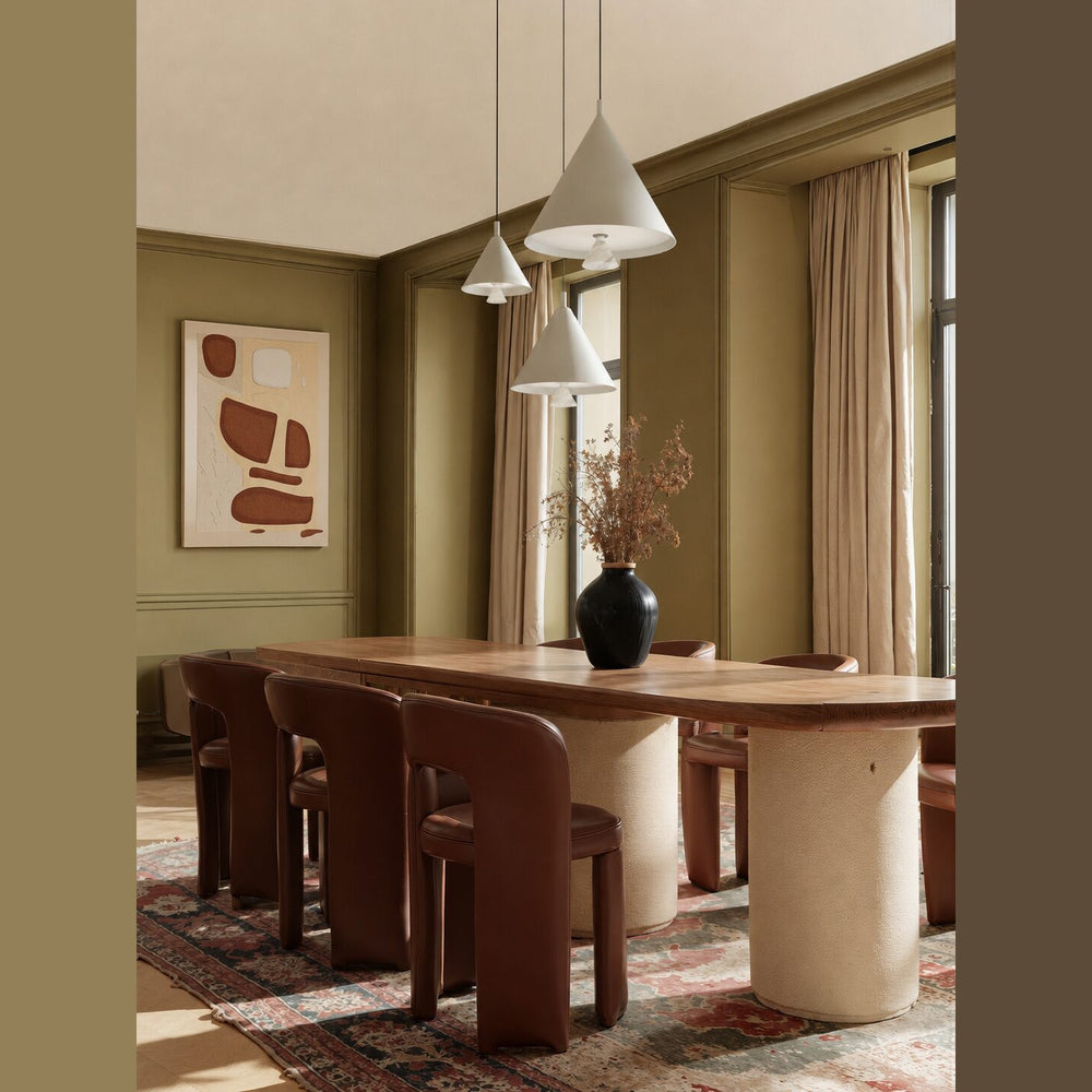 Marg Pendant Lamp trio of white cones hanging over a wooden dining table in an olive-green room